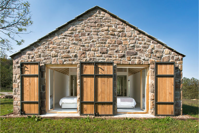The facades are covered with rough stone, metal and wood