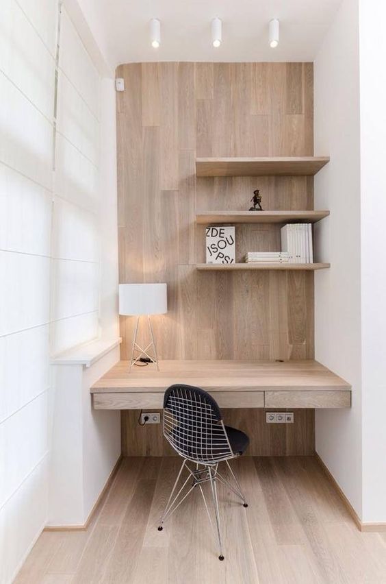 a minimal home office corner is done in white and natural wood, the furniture is clean and sleek