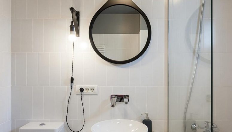 The bathroom is also monochromatic and sleek, with black touches
