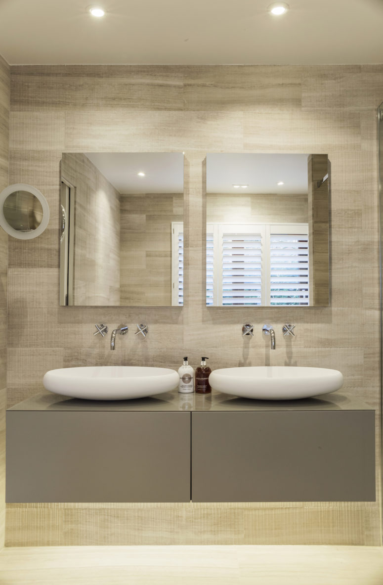 The master suite’s bathroom features a double sink vanity with matching wall mirrors and spotlights on the ceiling