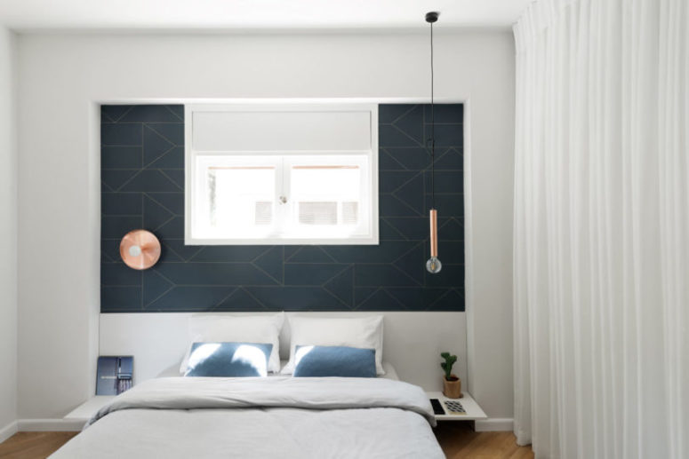 A geometric headboard wall and different lights for each side make the space cooler