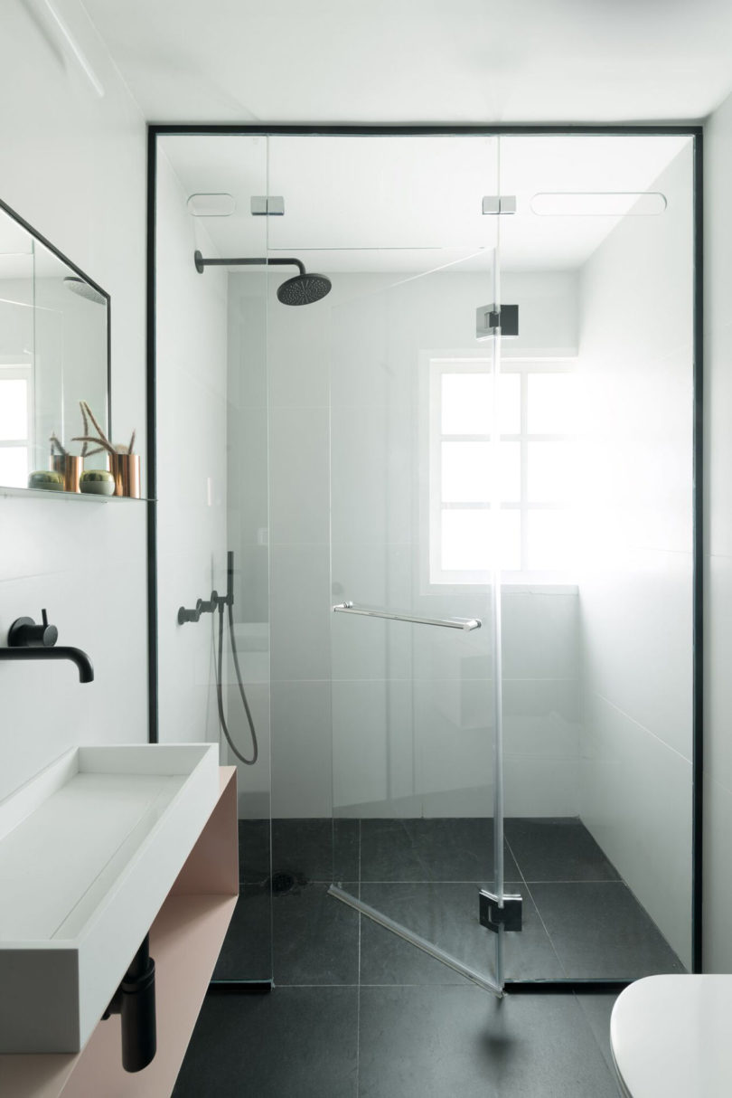 The second bathroom looks ethereal, with white tiles on the walls and black ones on the floor