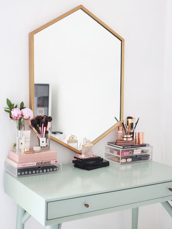 a geometric mirror in a gilded frame looks very cool and unusual and matches a mint vanity