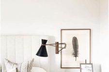 13 a large sconce with a metallic base and a black lampshade to make a statement