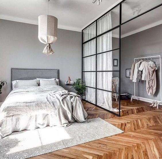 the closet in the bedroom is separated with a framed sliding glass door, which doesn't make the space look smaller