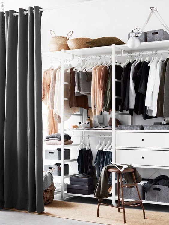 a closet in the bedroom is separated with a large curtain from the rest of the bedroom