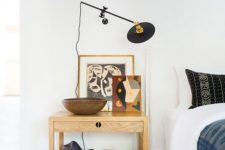 a super creative wall sconce on a long black leg to rotate it however you want and use it in an eclectic bedroom