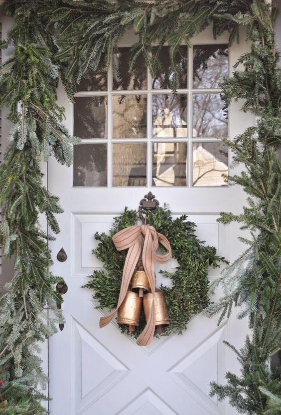 a lush evergreen garland to frame the font door and a wreath with bells to match the look