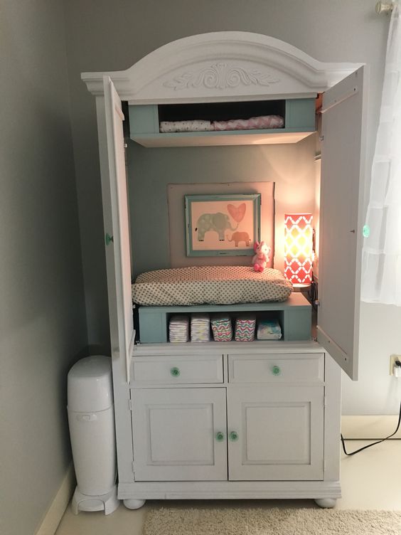 an armoire hides a changing table, storage and some additional light and makes the room look neat