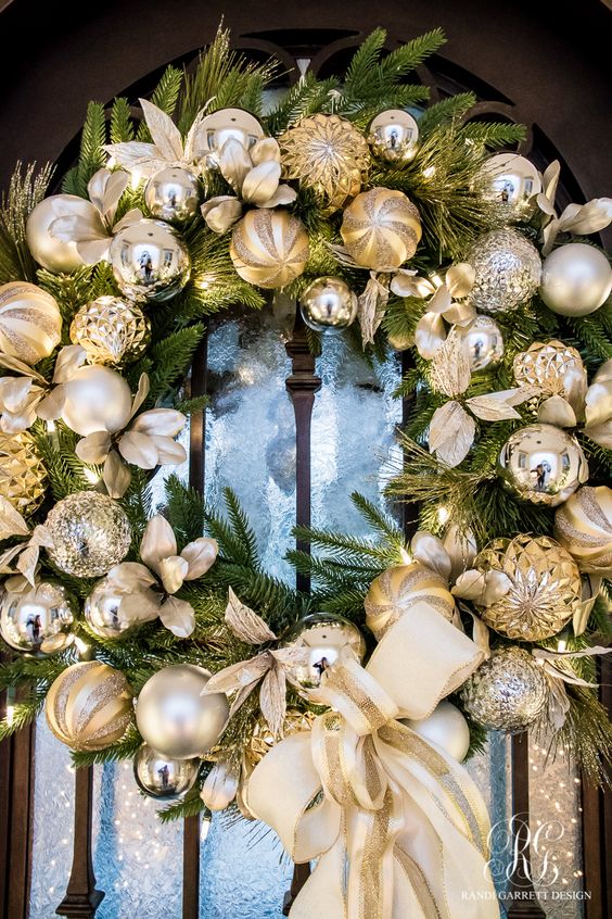 an evergreen wreath with gold and silver ornaments is a timeless idea for a front door