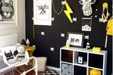 17 a black wall with a Batman print is made vivacious with yellow touches and artworks