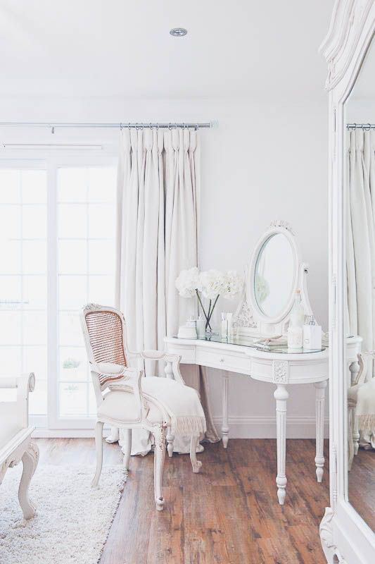 an exquisite mirror in a white frame on a matching refined vanity for a vintage space