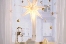 17 gold ornaments and a large star lantern will make your window holiday-like