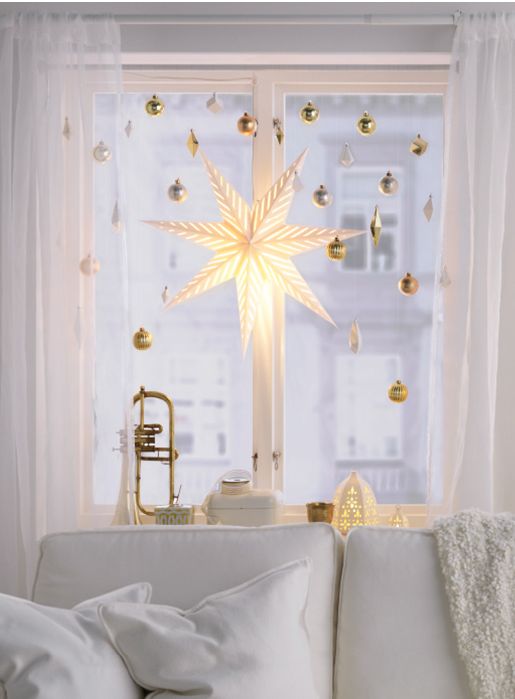 gold ornaments and a large star lantern will make your window holiday-like