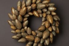 18 a Christmas wreath of gold pinecones looks glam and chic