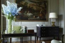 18 a vintage-inspired home office with paneled walls and a gorgeous painting