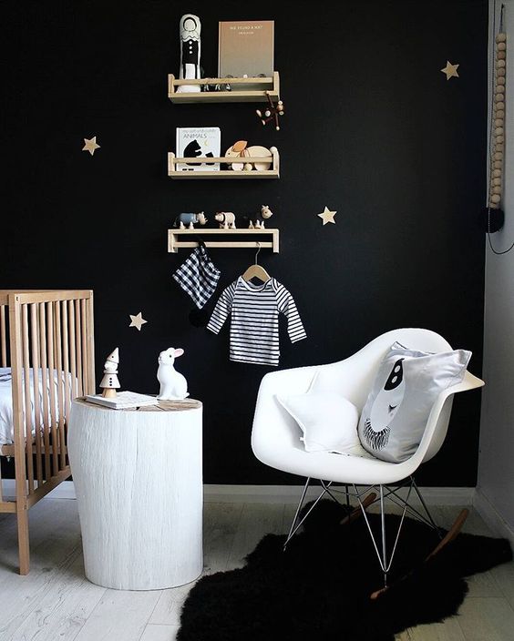 a Scandinavian space with a black statement wall, which is enlivened with wooden shelves and some stars