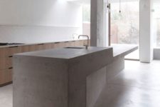 27 a large sculptural concrete kitchen island and wooden cabinets for a minimal ktichen