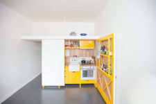 01 This chic mini kitchen was built for a studio apartment and features bold yellow cabinets and lots of storage space