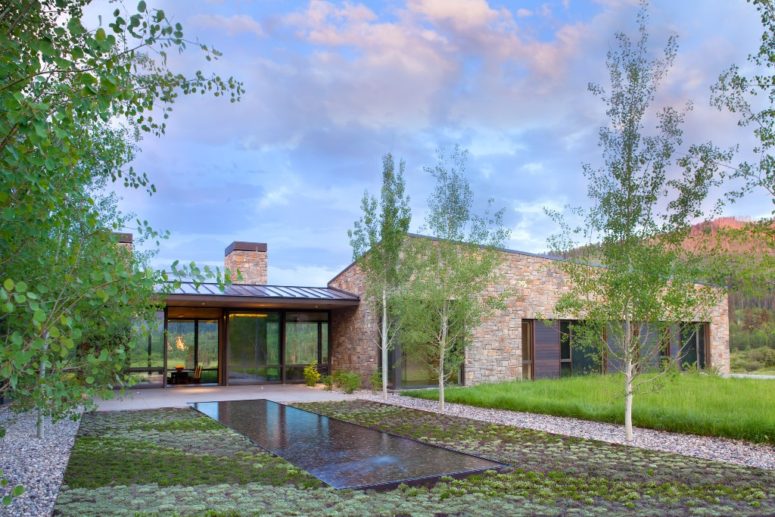 Outside you can see a pool, some greenery and a manicured lawn