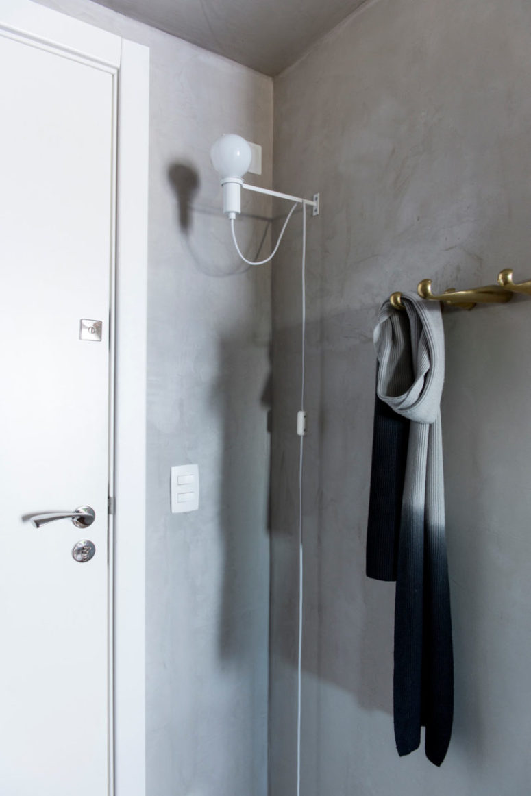 The entryway is done in concrete, with hooks and a lamp attached to the wall