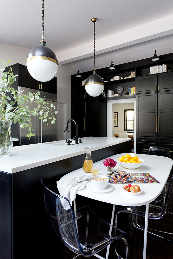 The small dining space is done with a white table and acrylic chairs for an edgy modern feel