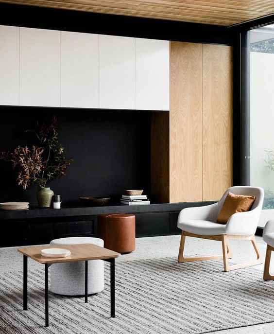 a contrasting living room with light-colored wood, black and white furniture