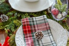 02 a cozy traditional table setting with evergreens, pinecones, plaid napkins and ornaments