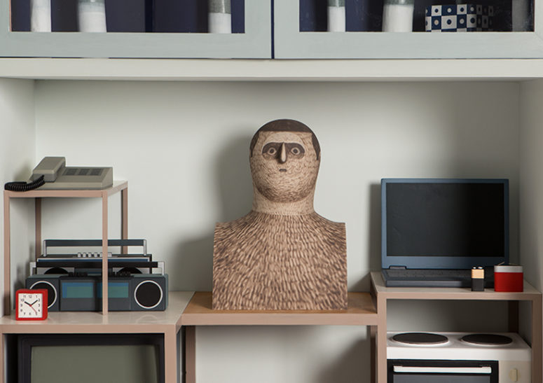 The bust of a man is surrounded by common objects that we used, all of them are fake