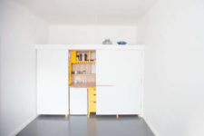 03 The kitchen design is done with light-colored wood to contrast thesunny yellow cabinets