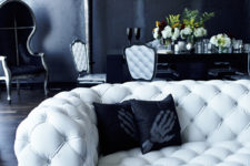 03 The space is done in black and very dark grey, with white upholstered furniture