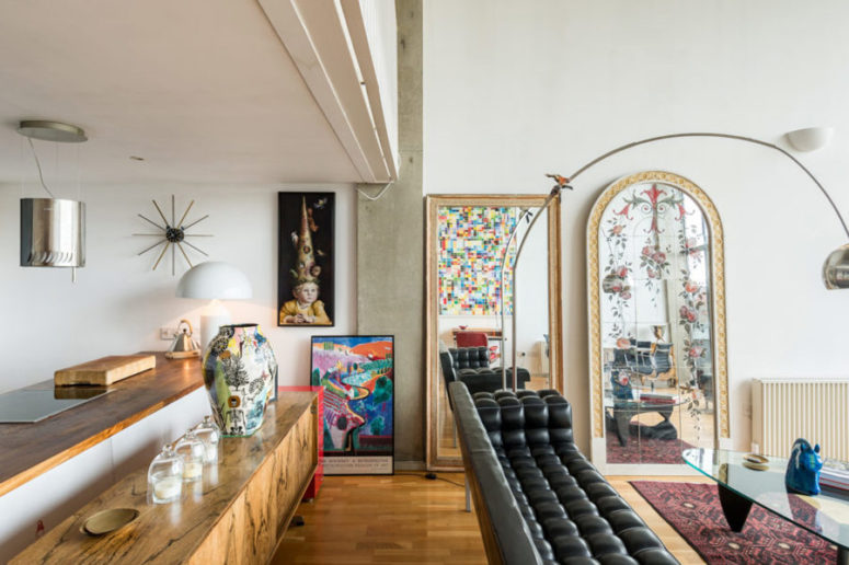 The black leather sofa and a wooden console separate the kitchen and living room