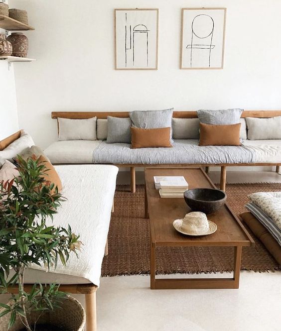 a comfy living room with a white backdrop and wooden furniture of various stains - darker and lighter ones