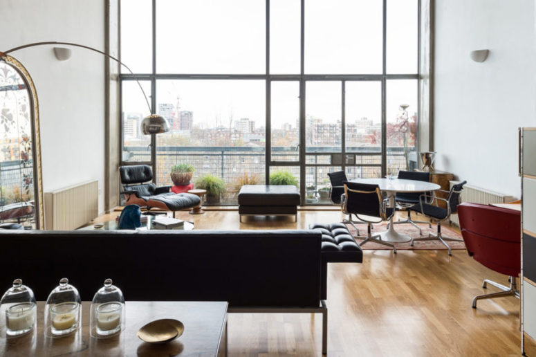 There's a dining zone by the window, with a round table and black chairs on casters