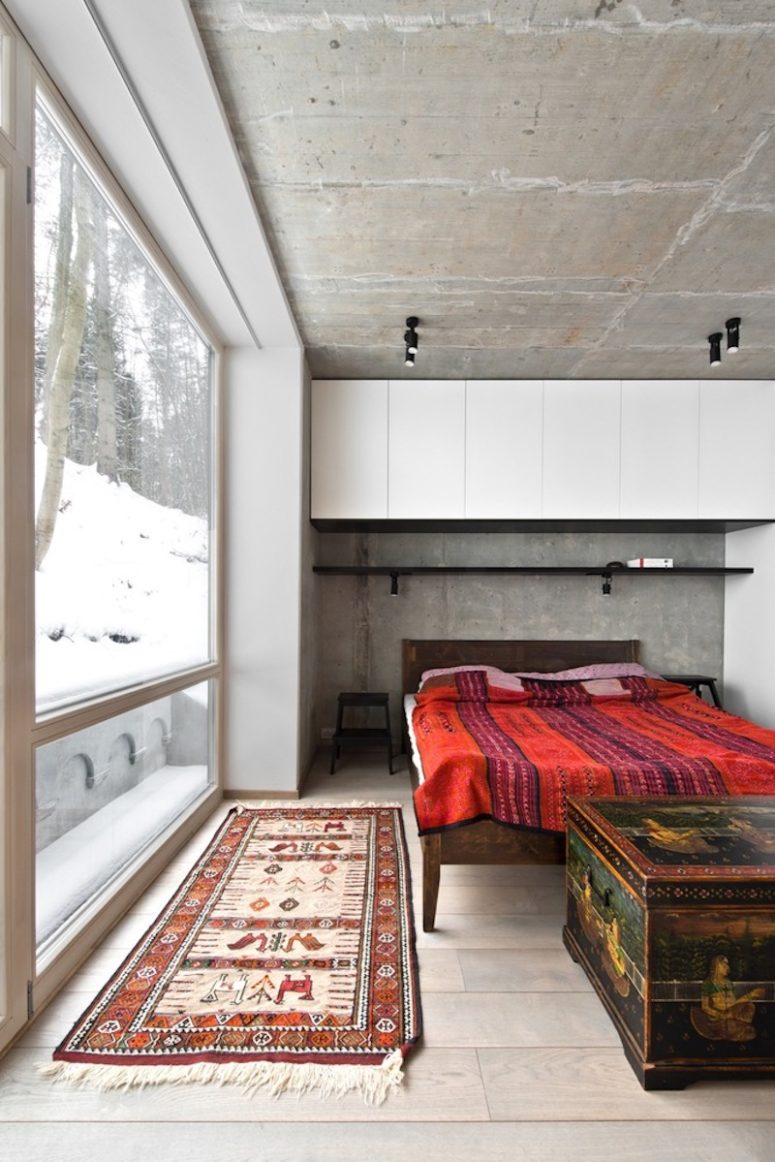 the master bedroom features raw concrete, wood and boho textiles and carved wooden items