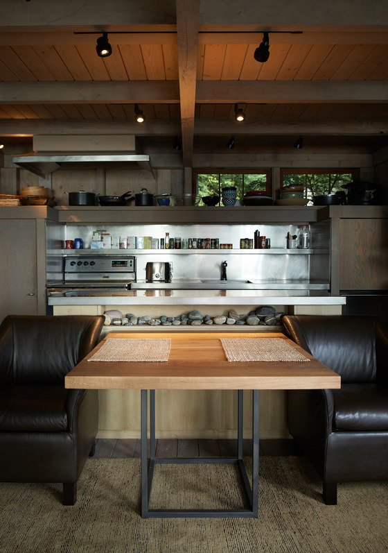 the kitchen features not only plywood cabinets but also pebbles and stainless steel appliances