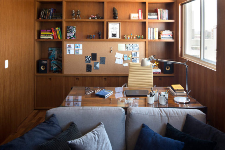 One wall is taken by storage, there's a desk and a comfy sofa next to it