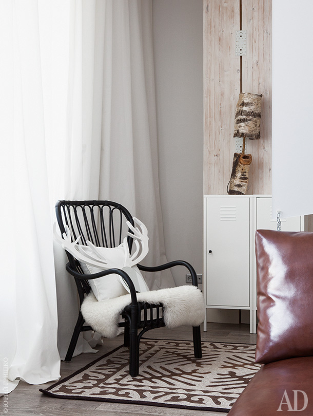 There's a comfy reading nook by the window, with a chair and some wooden touches
