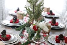 09 a cozy rustic table setting with a plaid runner, antlers, evergreens and pinecones for each place setting