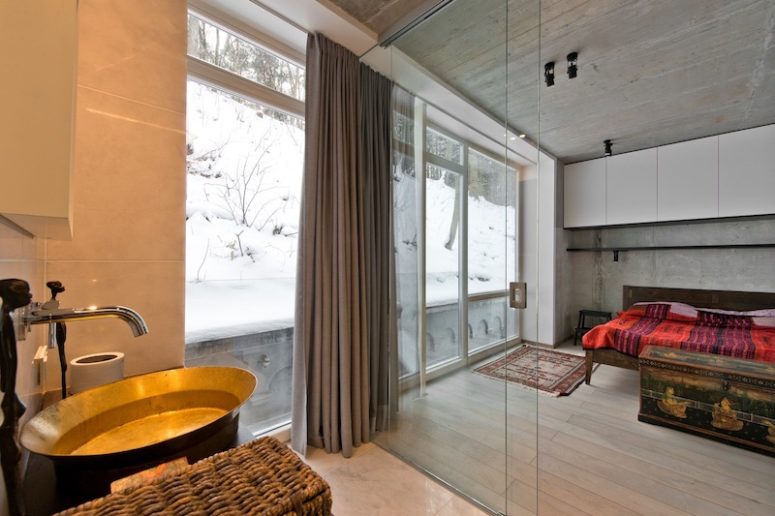 The bedroom is separated only with glass doors from the bedroom