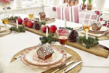 10 a cozy rustic tablescape with gingerbread house cookies, evergreens, pinecones, apples and candles