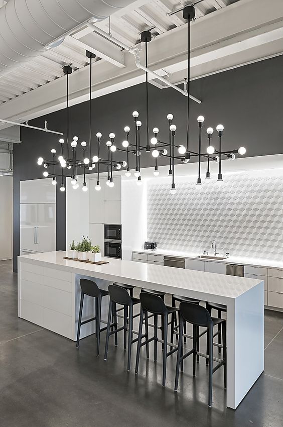a lit up tile backsplash and several industrial chandeliers for lighting up the space