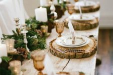 11 a lush garland with pinecones and candles, wood slice chargers and amber glasses for an elegant rustic tablescape