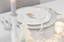 14 a clean white tablescape with a dove grey table runner, LEDs, stars, candles and wooden fir trees