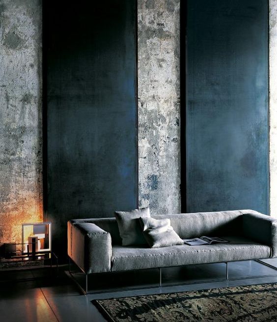 a moody space can be accentuated with blackened metal wall panels on raw concrete walls