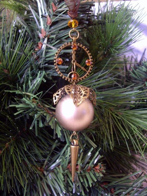 a steampunk ornament with beads, gears and a pink bauble