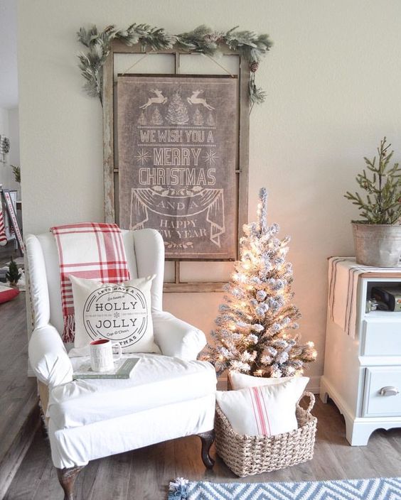 a vintage Christmas sign topped with a snowy evergreen garland