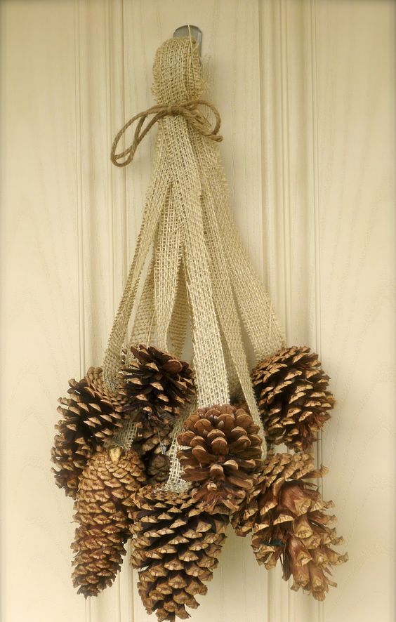 a burlap and pinecone door decoration can be hung on a door, mantel or railing