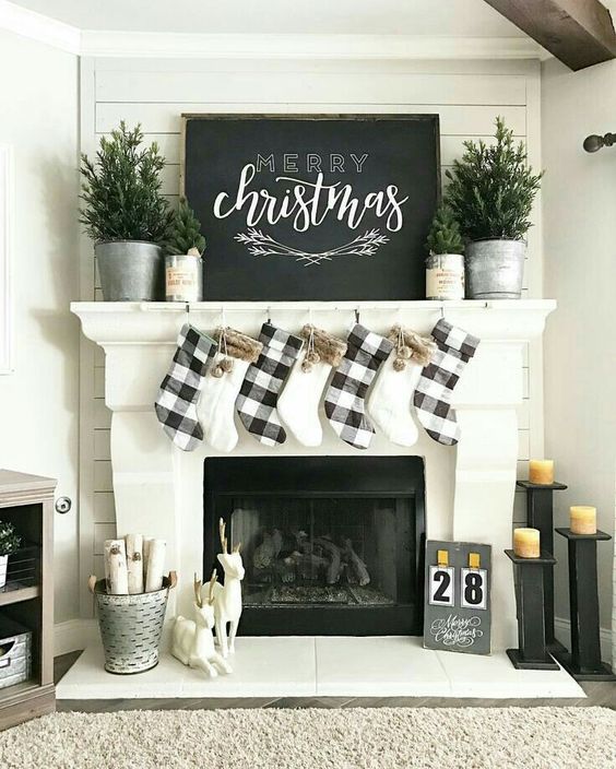 buffalo check stockings and evergreens in buckets for a chic farmhouse mantel