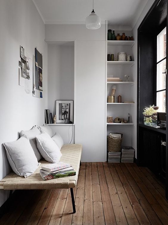 simple white cabinets and open shelves and a light-colored woven bench